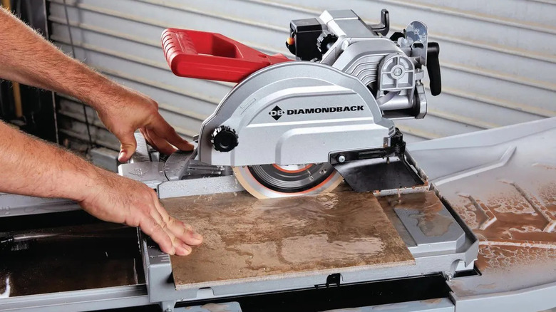 A person uses the Diamondback Wet Tile Saw
