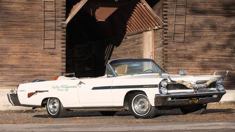 1963 Pontiac Bonneville "Nudie Mobile" parked in front of a wooden building