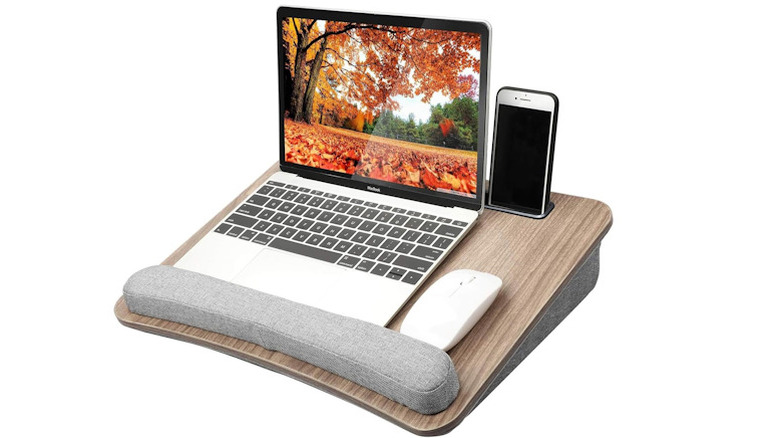 Portable lap desk with a laptop and phone in the slots on a white background