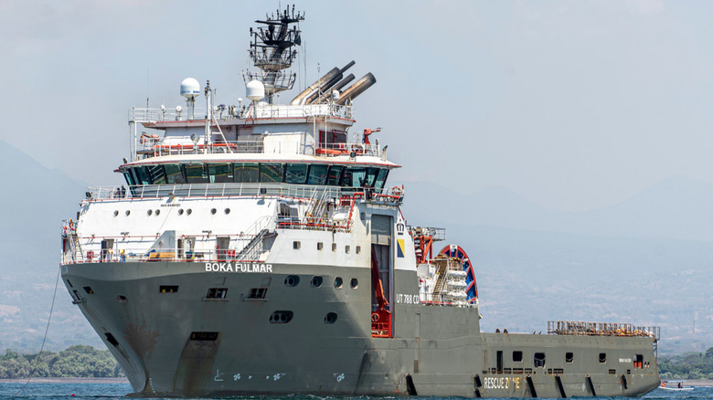 A large grey and white ship riding at anchor