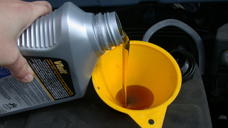 Oil being poured into an engine via a funnel