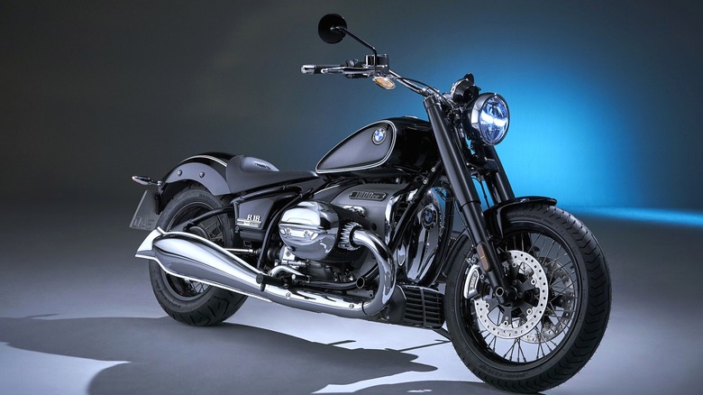 A black BMW R 18 First Edition sitting under studio lighting, deep blue glow behind it.