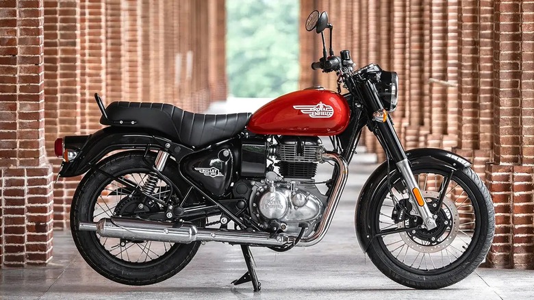 A 2023 red Royal Enfield Bullet 350 parked next to a series of brick archways.