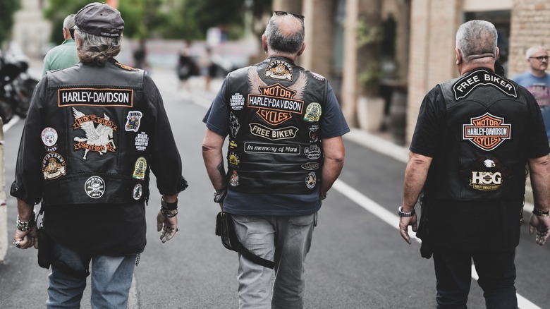 Three bikers at a H.O.G. rally wearing Harley-Davidson vests