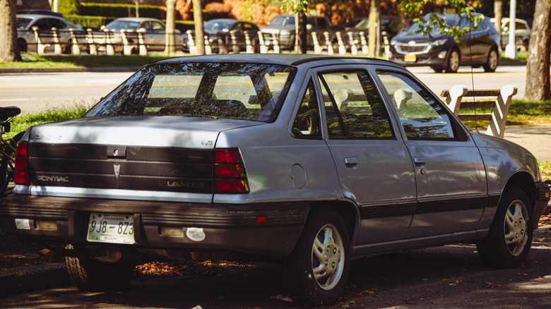 1988 Pontiac LeMans sedan, parked in shade, rear-right 3/4 view