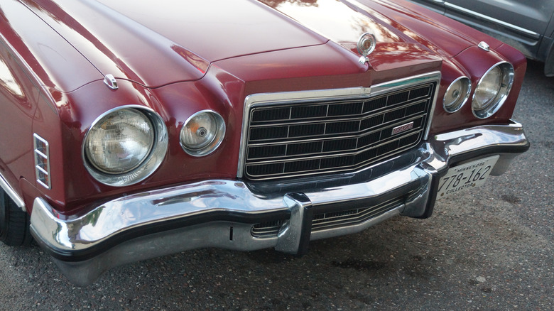 A close-up of the front end of a red 1975 Dodge Charger SE
