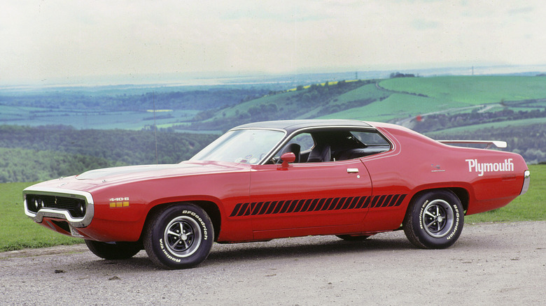 Side view of red 1971 Plymouth Road Runner parked in countryside
