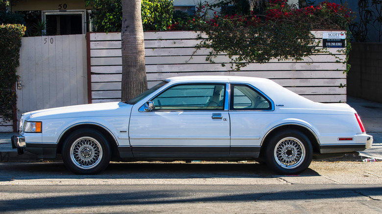Side view of white Lincoln Mark VII LSC parked on street.