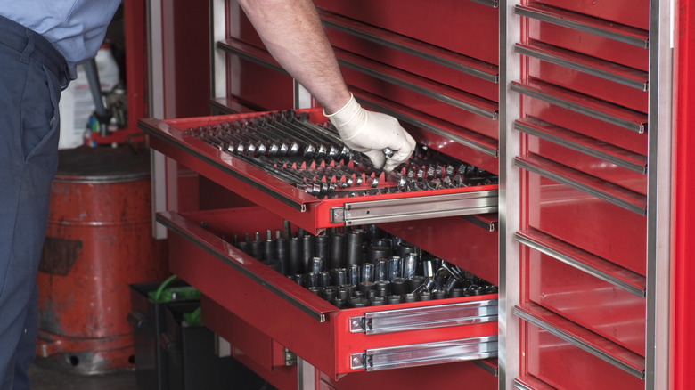 Person putting tools into a storage chest
