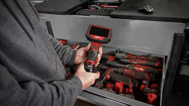 Man picking up tool from toolbox