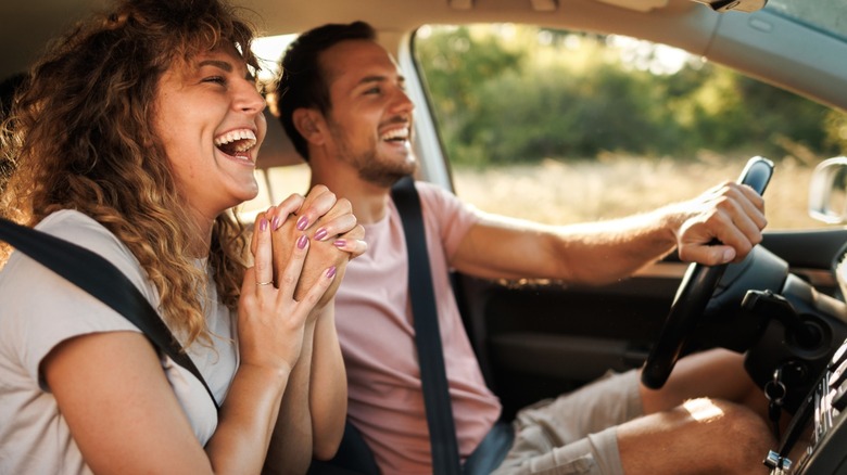 Man and woman laughing in car