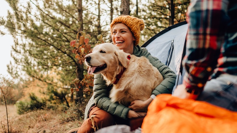 Woman hugging dog while camping