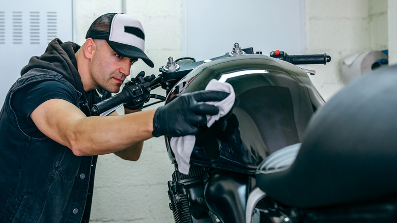 Person cleaning motorcycle