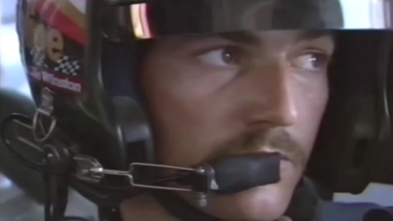 Davey Allison wearing a helmet inside of his race car