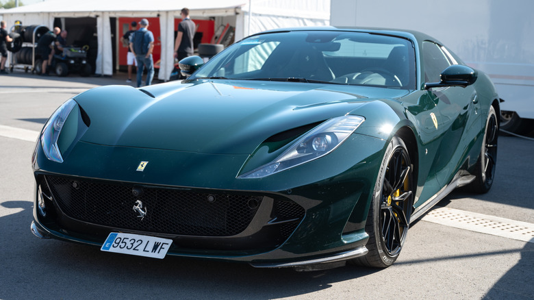 A dark green Ferrari 812 Superfast parked outside.