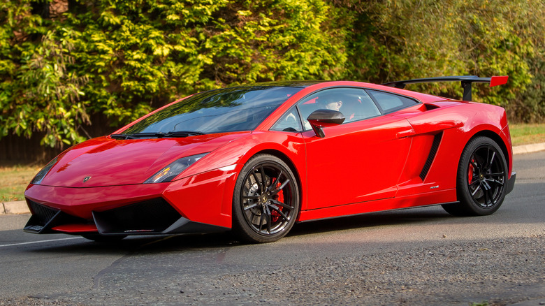 A red Lamborghini Gallardo Superleggera driven on a road.
