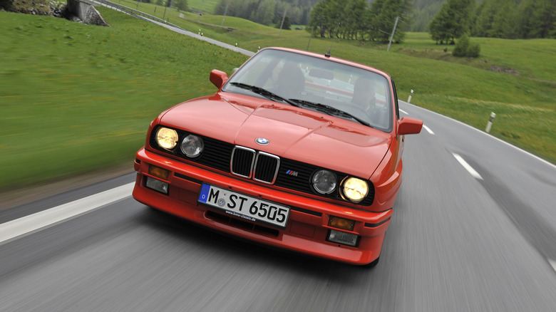 BMW E30 M3 driving on European country road, front-view