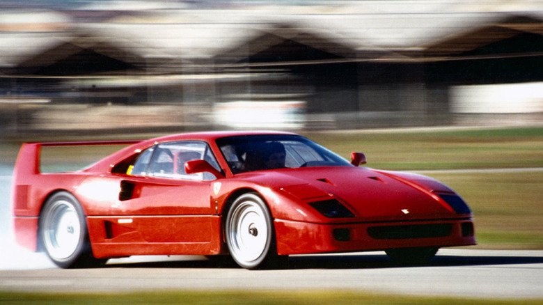 Ferrari F40 driving at speed on racetrack, front-right 3/4 view