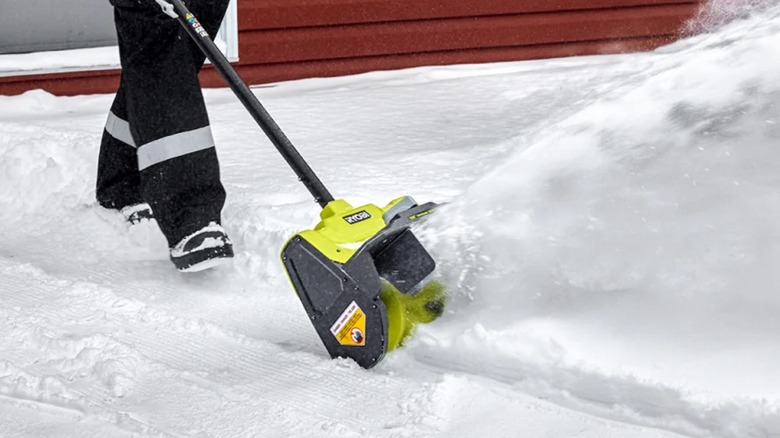A person using the 40V 12" Snow Shovel.