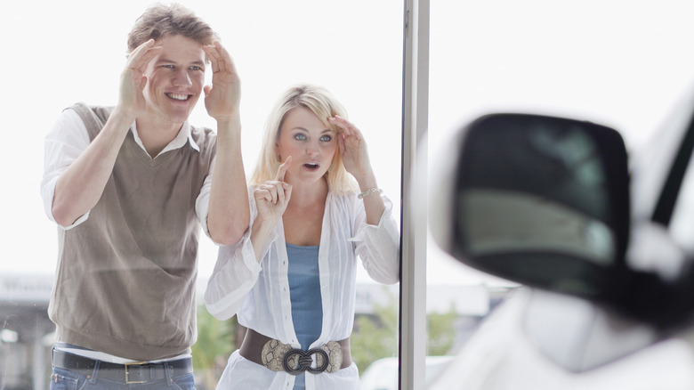 couple looking through dealership window