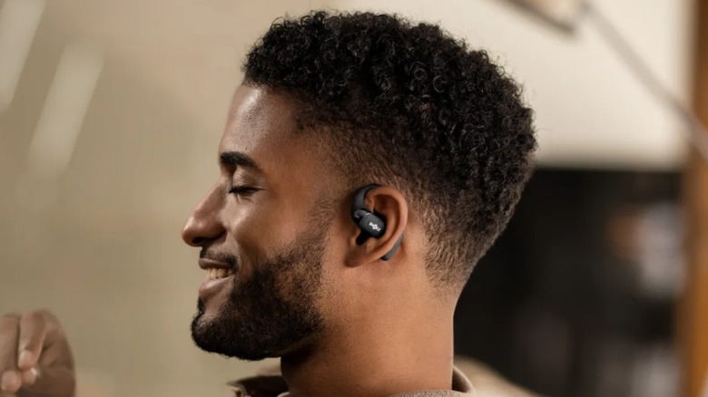 Man smiling while wearing Shokz OpenFit 2 SE Open-Ear True Wireless Earbuds