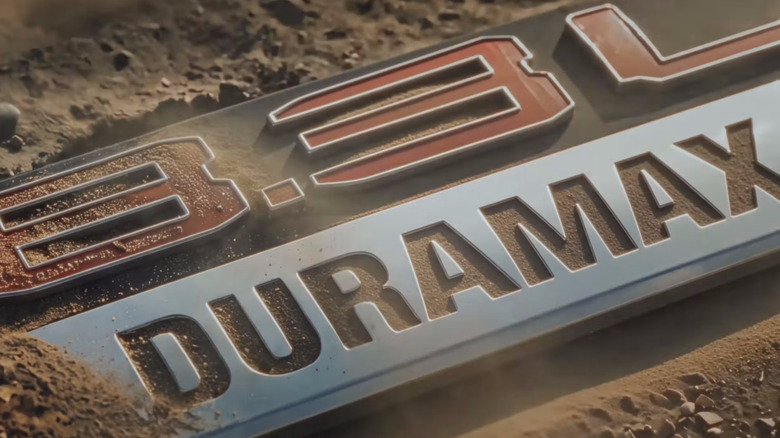 8.3L Duramax logo partially covered in sandy terrain