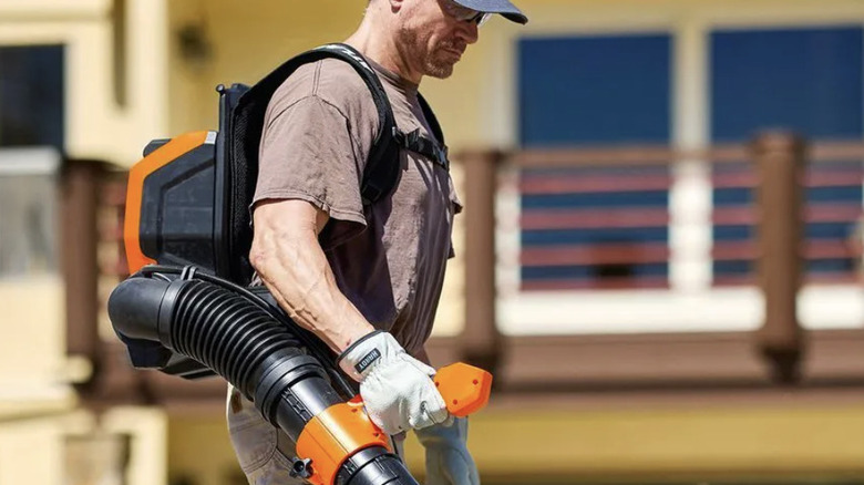 A man using the Atlas 80V Brushless Cordless Backpack Blower