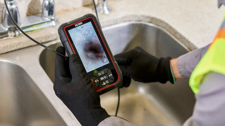 Close-up of a workman holding the ICON Professional handheld inspection camera