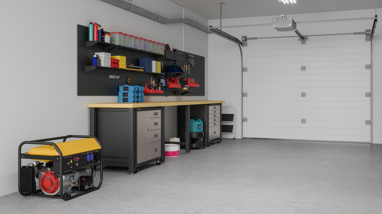 A very clean garage with a wall of tools, storage solutions, and a generator next to the workbench