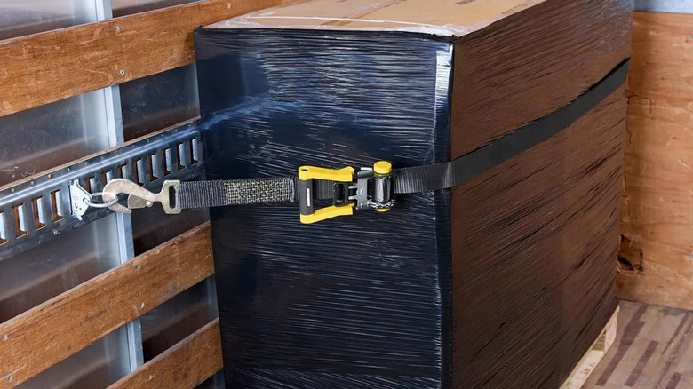 A Haul-Master tie-down holding cargo to the wall inside a shipping container