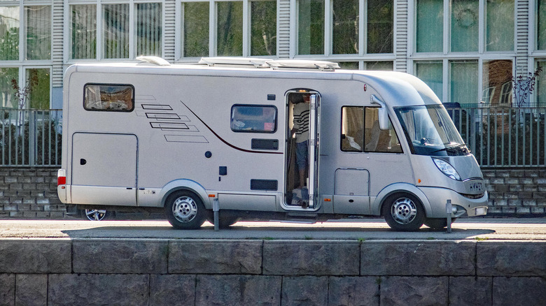 A white RV parked by a river