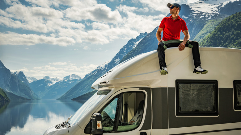 man sitting on roof of RV