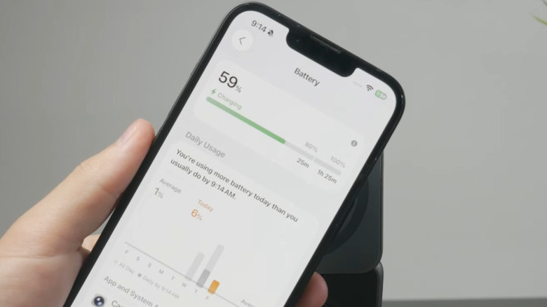 Hand holding iPhone showing charge time estimates