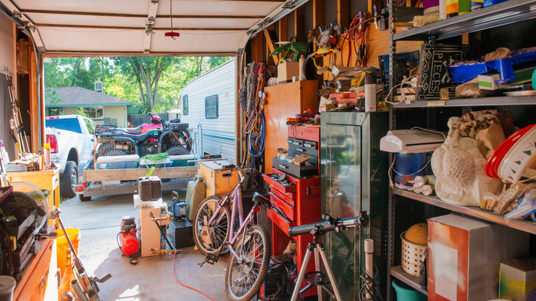 A cluttered garage with bikes, storage racks, and equipment.
