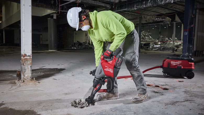person using demolition hammer on concrete