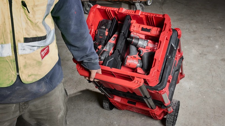 A person wheeling a Milwaukee Packout stack with a Low-Profile Crate on top