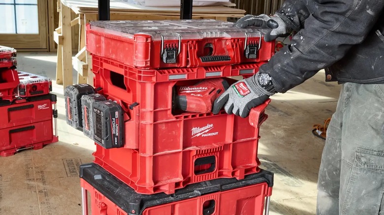 A person retrieving a tool from a Milwaukee Packout XL Crate