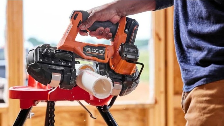 Ridgid Subcompact band saw being used to cut through PVC piping.