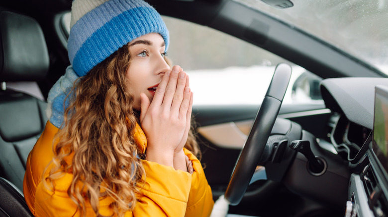 Woman with cold hands in a car