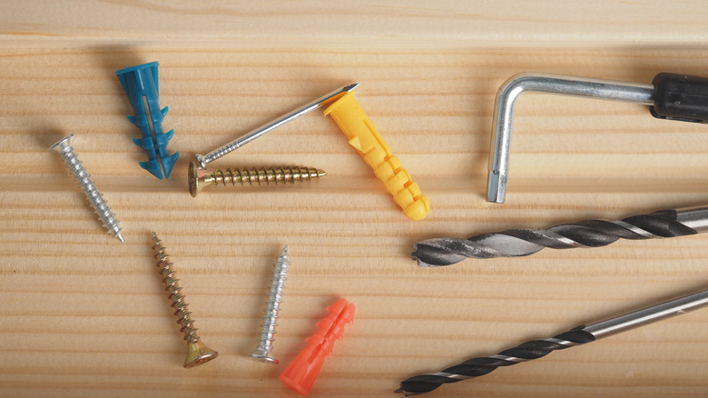 Tools and fasteners in a wooden drawer.