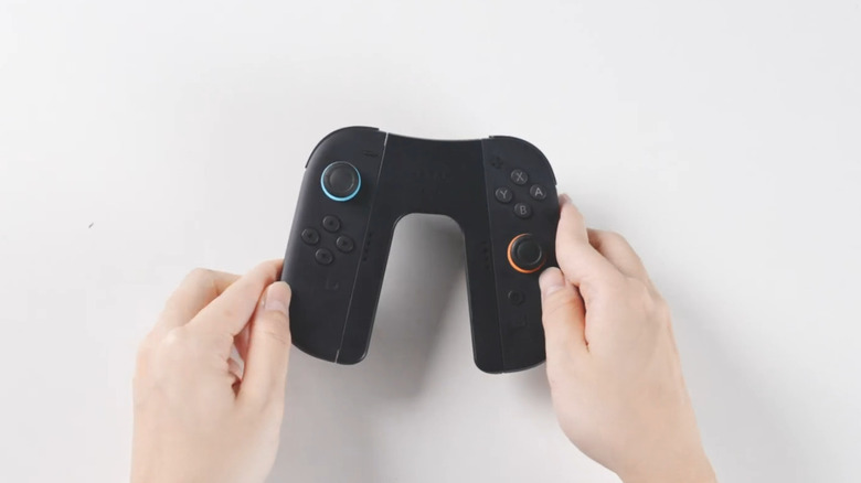 A Switch 2 charging Joy-Con grip held between two hands.