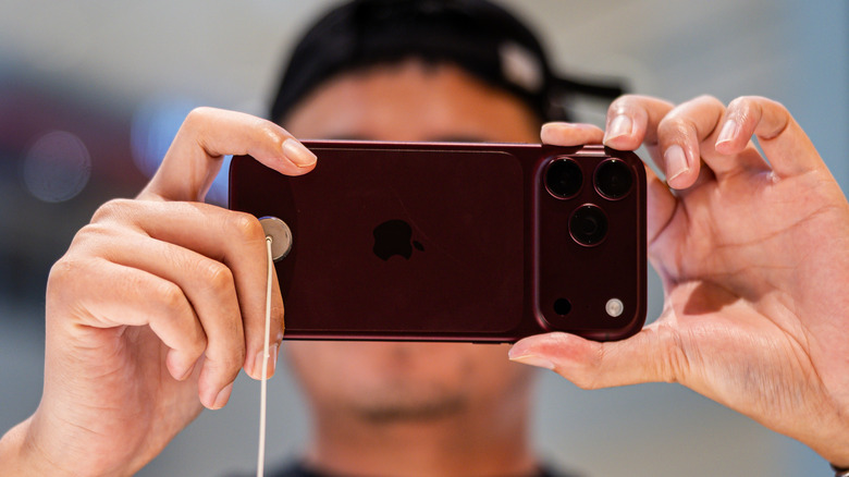 A person holding iPhone 18 Pro up to take a picture.