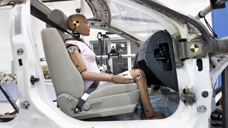 A crash dummy inside a car during a crash test.