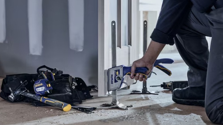 Person lifting a door with an Irwin Quick Lift Manual Material Handling Jack