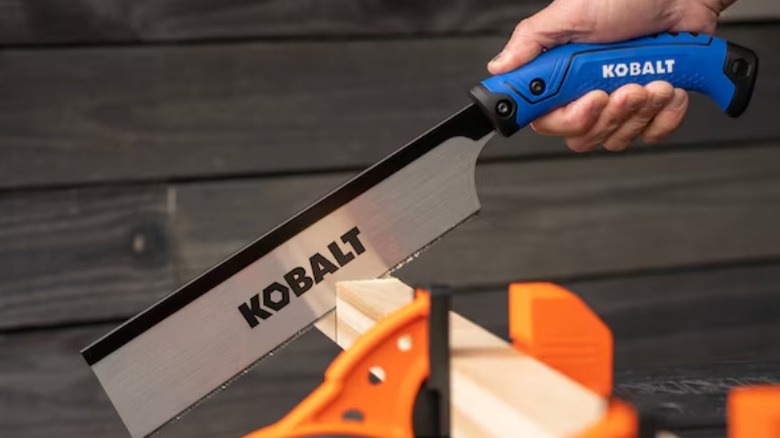 Person cutting plywood with a Kobalt 10-inch Extra Fine Cut Pull Saw
