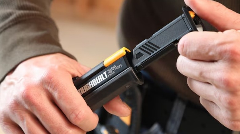Person loading magazine into a ToughBuilt Reload Utility Knife