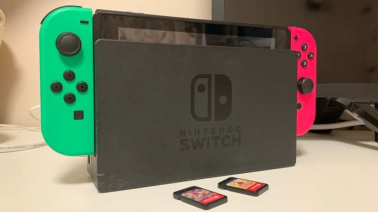 A Nintendo Switch in its dock with two game cards