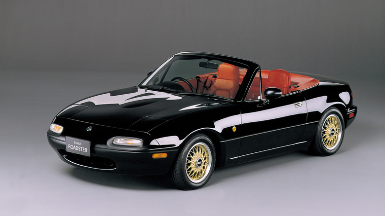 First-gen Mazda MX-5 Miata front 3/4 view with gold BBS wheels