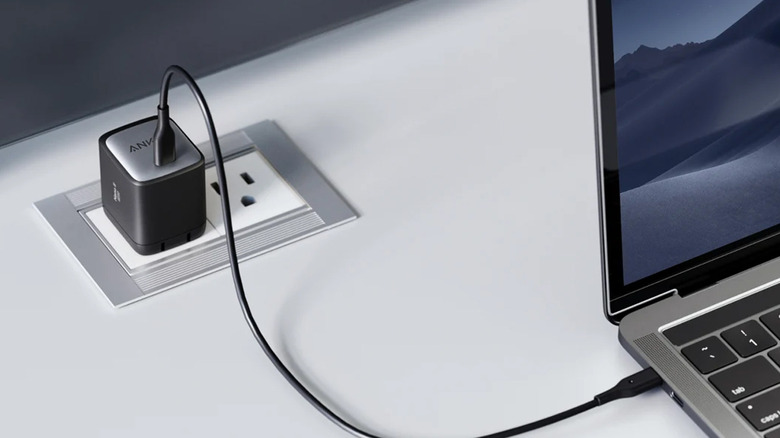 Laptop plugged into an Anker charger.