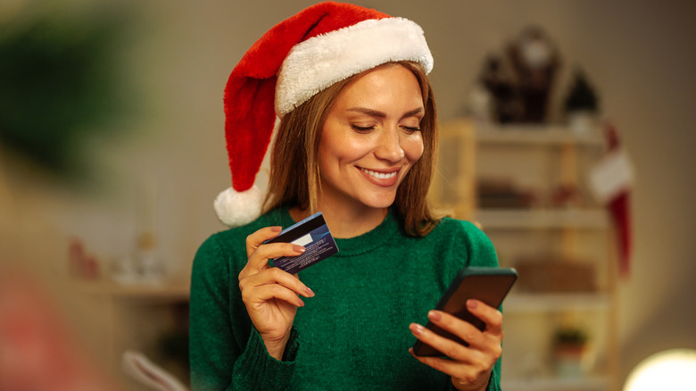 person holding credit card in santa hat